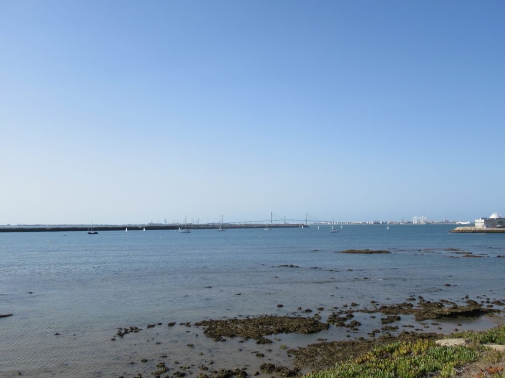 An image of boats at anchor with Cadiz bridge in the far background