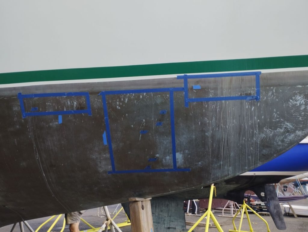 A boat's hull showing blocks marked out with blue masking tape