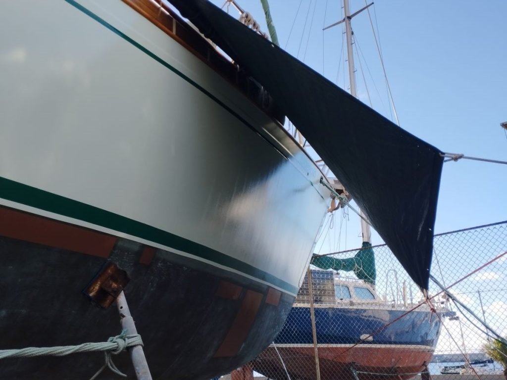 A boat's hull with a tarpaulin shade over it to protect it from rain